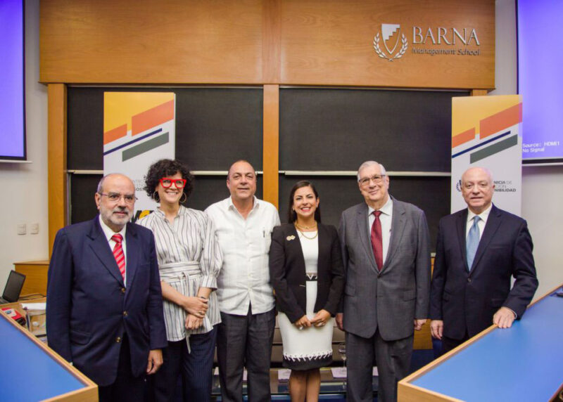 Grupo de personas de pie frente a un podio, mostrando un ambiente de reunión o evento formal.