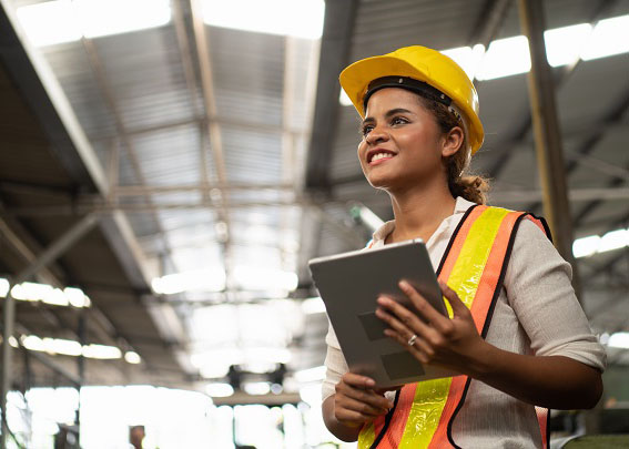 Mujer con casco de seguridad sosteniendo una tableta