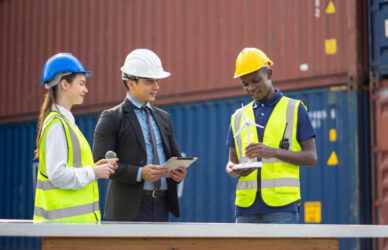 trabajadores de la construcción discuten un proyecto cerca de contenedores de envío